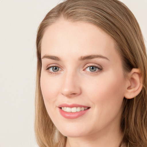 Joyful white young-adult female with long  brown hair and blue eyes