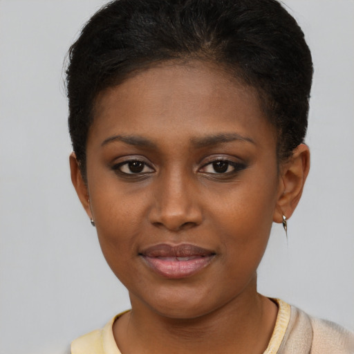 Joyful black young-adult female with short  brown hair and brown eyes