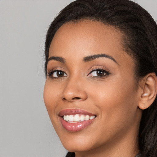 Joyful latino young-adult female with long  black hair and brown eyes