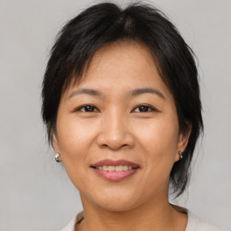 Joyful asian adult female with medium  brown hair and brown eyes