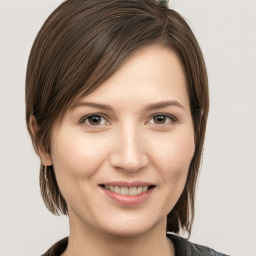 Joyful white young-adult female with medium  brown hair and grey eyes