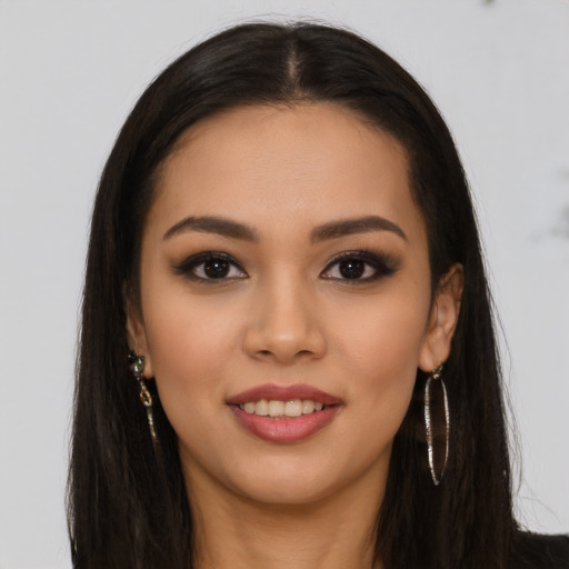 Joyful latino young-adult female with long  brown hair and brown eyes