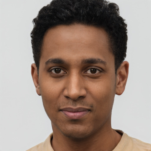 Joyful black young-adult male with short  black hair and brown eyes
