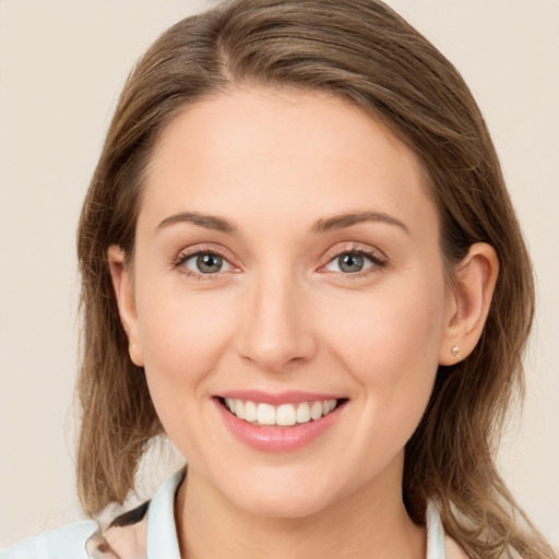 Joyful white young-adult female with medium  brown hair and green eyes