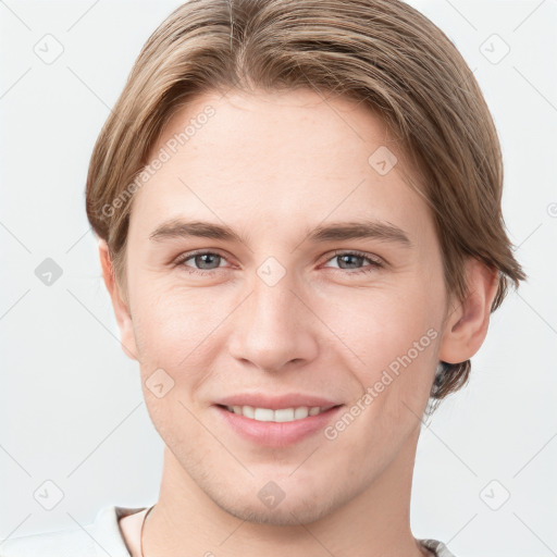 Joyful white young-adult male with short  brown hair and grey eyes