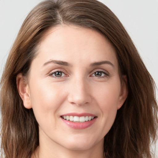 Joyful white young-adult female with long  brown hair and brown eyes