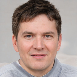 Joyful white adult male with short  brown hair and grey eyes