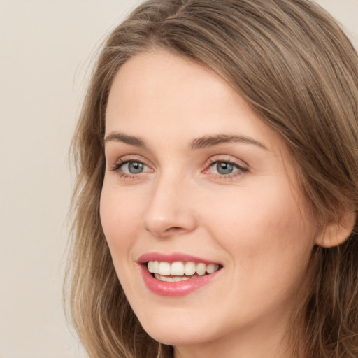 Joyful white young-adult female with long  brown hair and green eyes