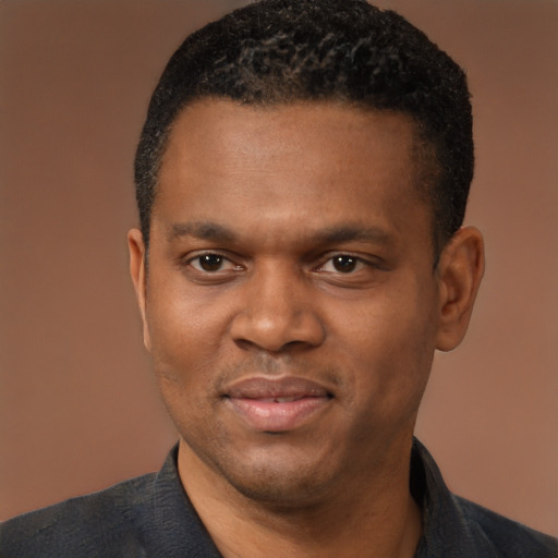 Joyful black young-adult male with short  black hair and brown eyes