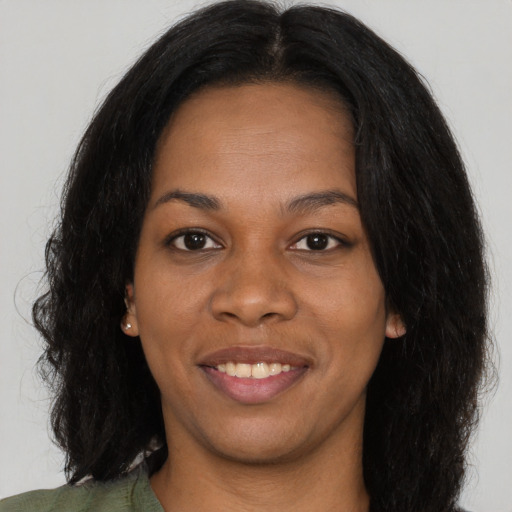 Joyful black young-adult female with long  black hair and brown eyes