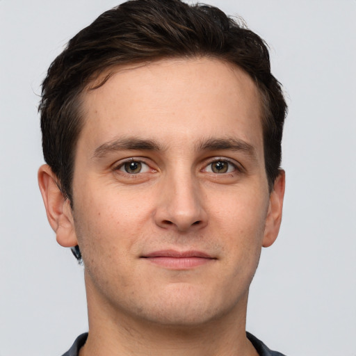 Joyful white young-adult male with short  brown hair and grey eyes