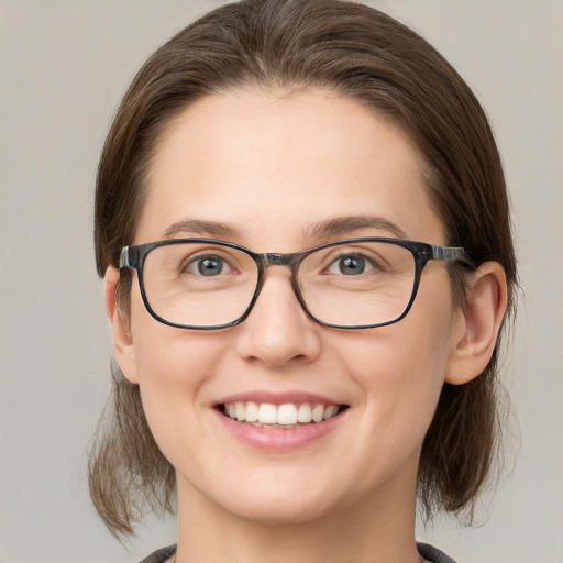 Joyful white young-adult female with medium  brown hair and grey eyes