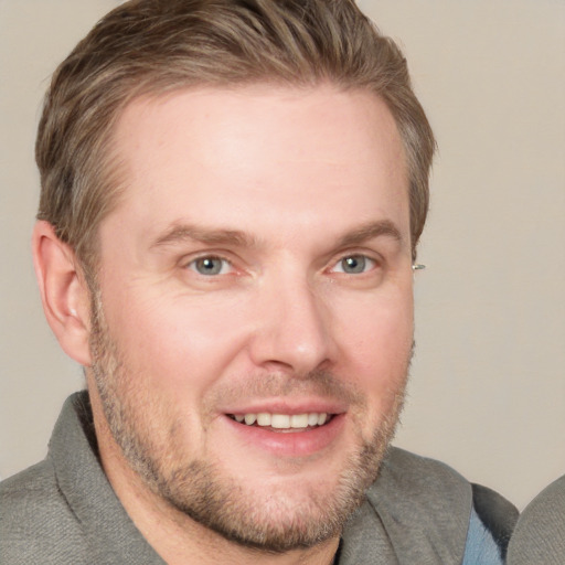 Joyful white adult male with short  brown hair and grey eyes