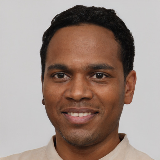 Joyful black young-adult male with short  black hair and brown eyes