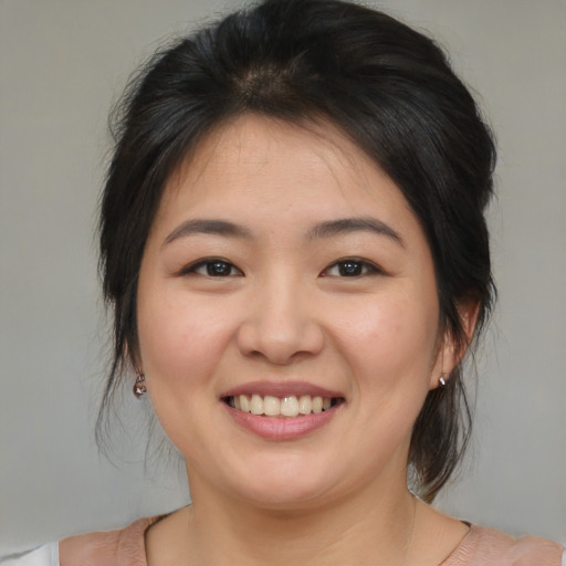 Joyful asian young-adult female with medium  brown hair and brown eyes