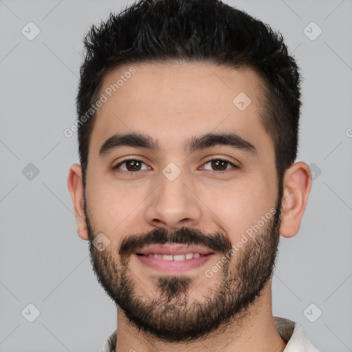 Joyful white young-adult male with short  black hair and brown eyes