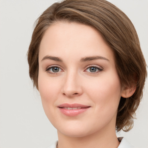 Joyful white young-adult female with medium  brown hair and green eyes