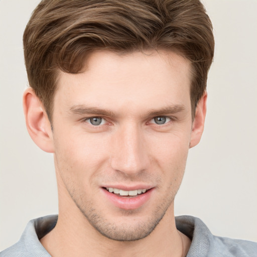 Joyful white young-adult male with short  brown hair and grey eyes