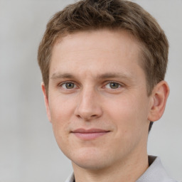 Joyful white young-adult male with short  brown hair and grey eyes