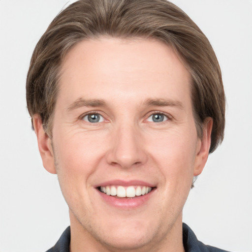 Joyful white adult male with short  brown hair and grey eyes