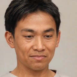 Joyful asian adult male with short  brown hair and brown eyes