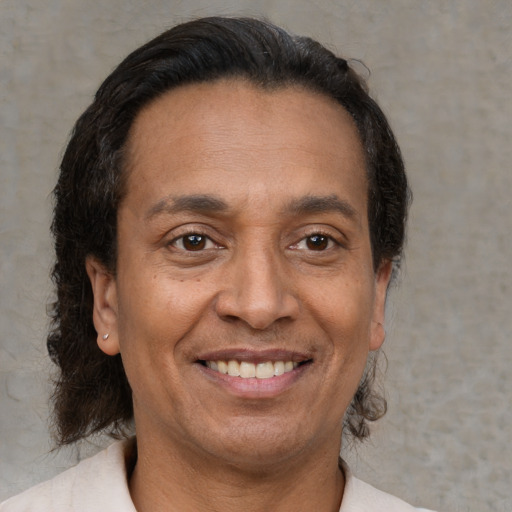 Joyful latino adult male with short  brown hair and brown eyes
