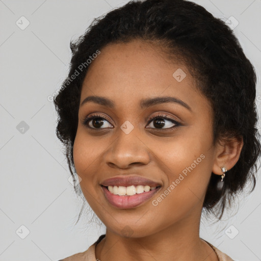 Joyful black young-adult female with long  black hair and brown eyes