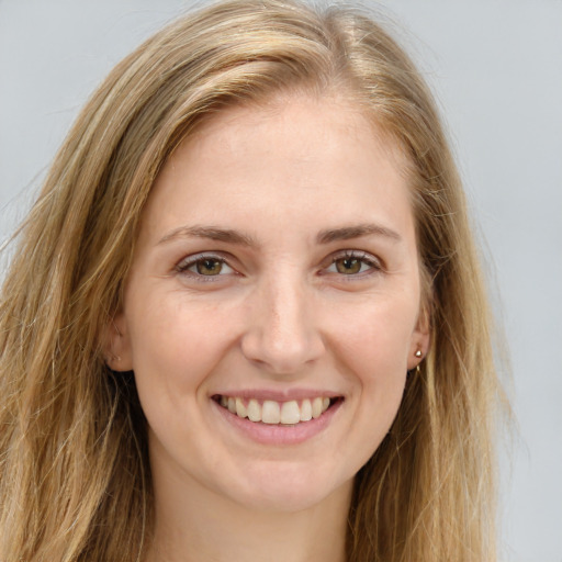 Joyful white young-adult female with long  brown hair and green eyes