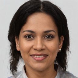 Joyful latino adult female with medium  brown hair and brown eyes