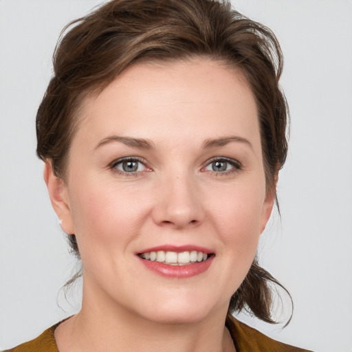 Joyful white young-adult female with medium  brown hair and grey eyes