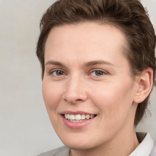 Joyful white young-adult female with short  brown hair and grey eyes