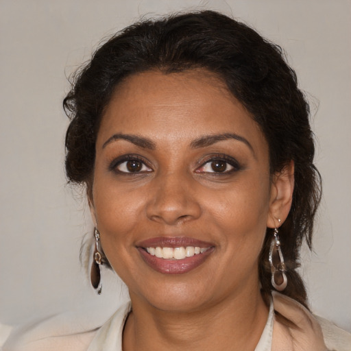 Joyful black adult female with medium  brown hair and brown eyes