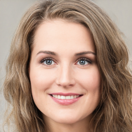 Joyful white young-adult female with long  brown hair and green eyes