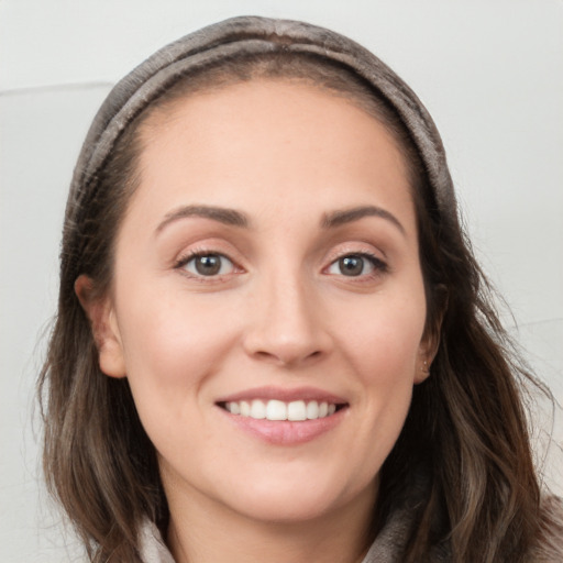 Joyful white young-adult female with long  brown hair and grey eyes