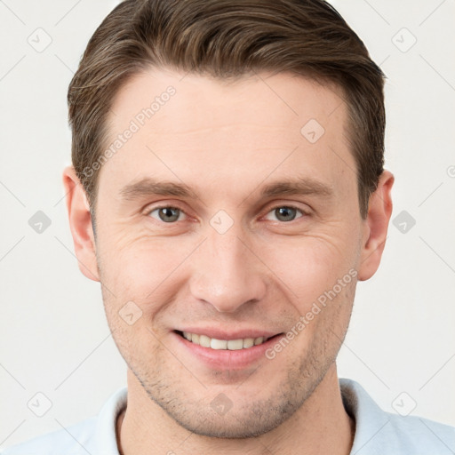 Joyful white young-adult male with short  brown hair and grey eyes