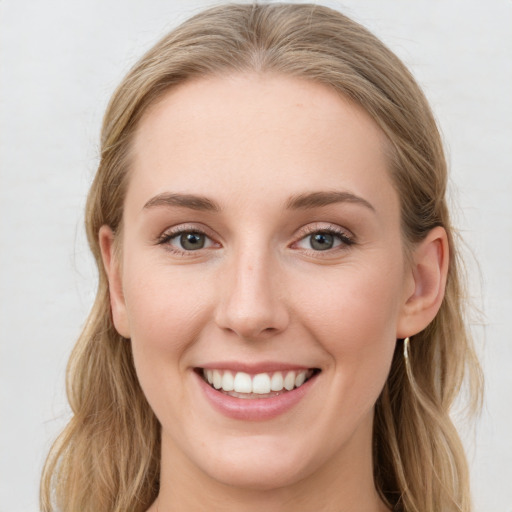 Joyful white young-adult female with long  brown hair and blue eyes