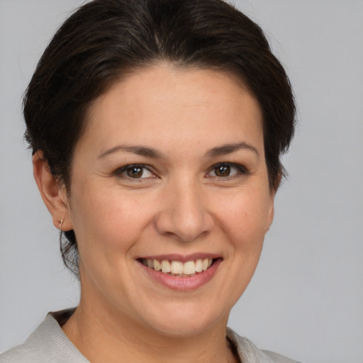 Joyful white adult female with medium  brown hair and brown eyes