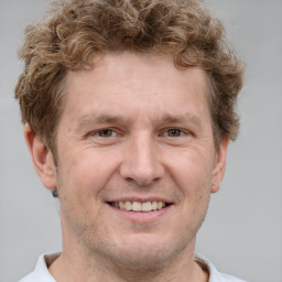 Joyful white adult male with short  brown hair and grey eyes