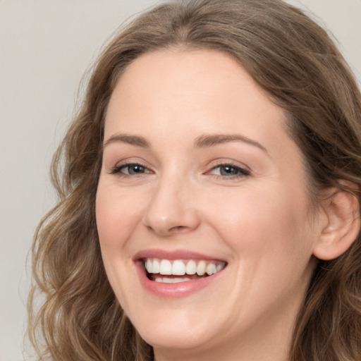 Joyful white young-adult female with long  brown hair and grey eyes