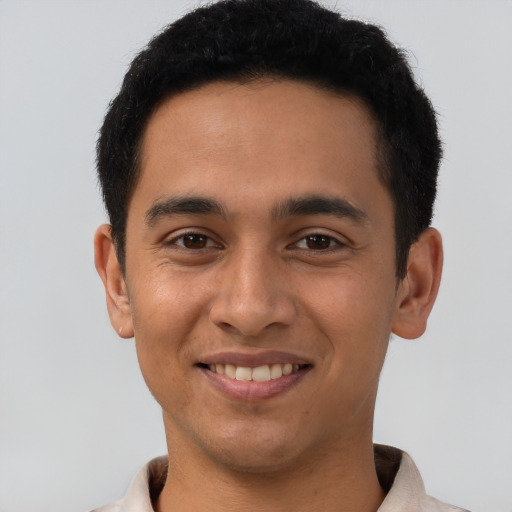 Joyful latino young-adult male with short  brown hair and brown eyes