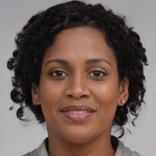 Joyful black young-adult female with medium  brown hair and brown eyes