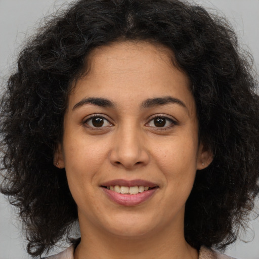 Joyful latino young-adult female with medium  brown hair and brown eyes