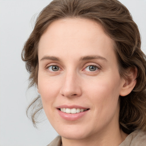 Joyful white young-adult female with medium  brown hair and blue eyes