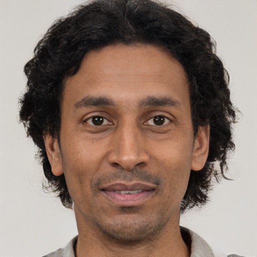 Joyful black adult male with short  black hair and brown eyes