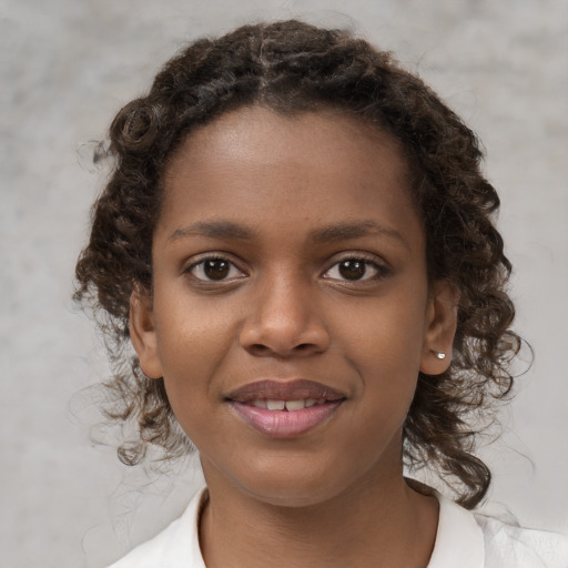 Joyful black child female with medium  brown hair and brown eyes