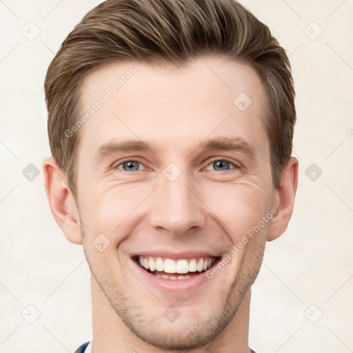 Joyful white young-adult male with short  brown hair and grey eyes