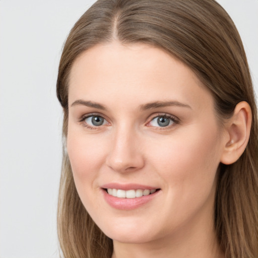 Joyful white young-adult female with long  brown hair and grey eyes