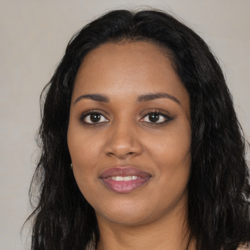 Joyful black young-adult female with long  black hair and brown eyes