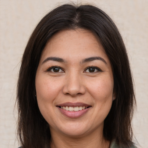 Joyful latino young-adult female with long  brown hair and brown eyes