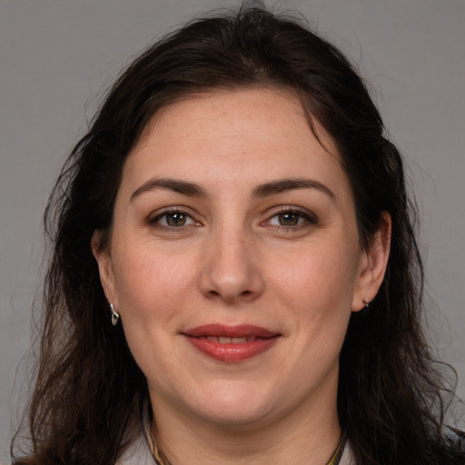 Joyful white adult female with long  brown hair and brown eyes